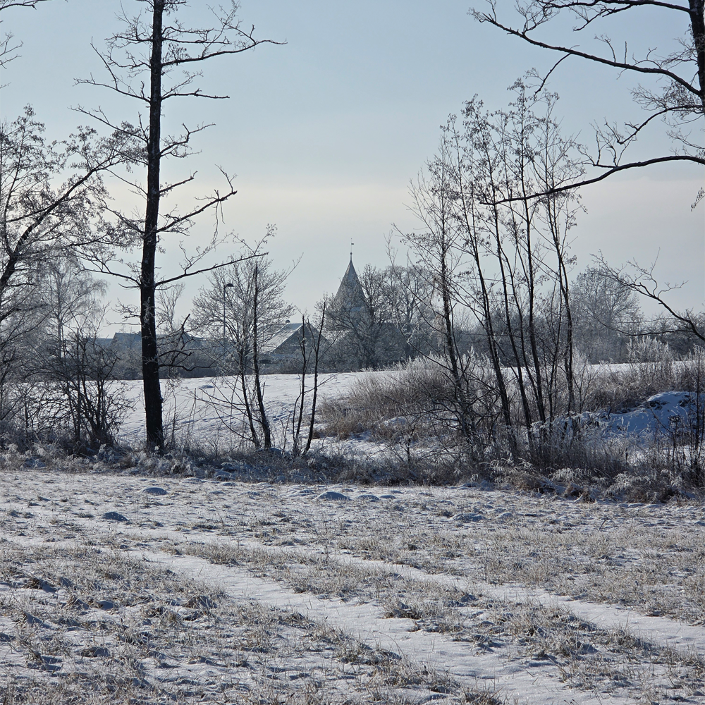 Blick auf die eingeschneite St. Martinskirche in der Gemeinde W&ouml;rnitz